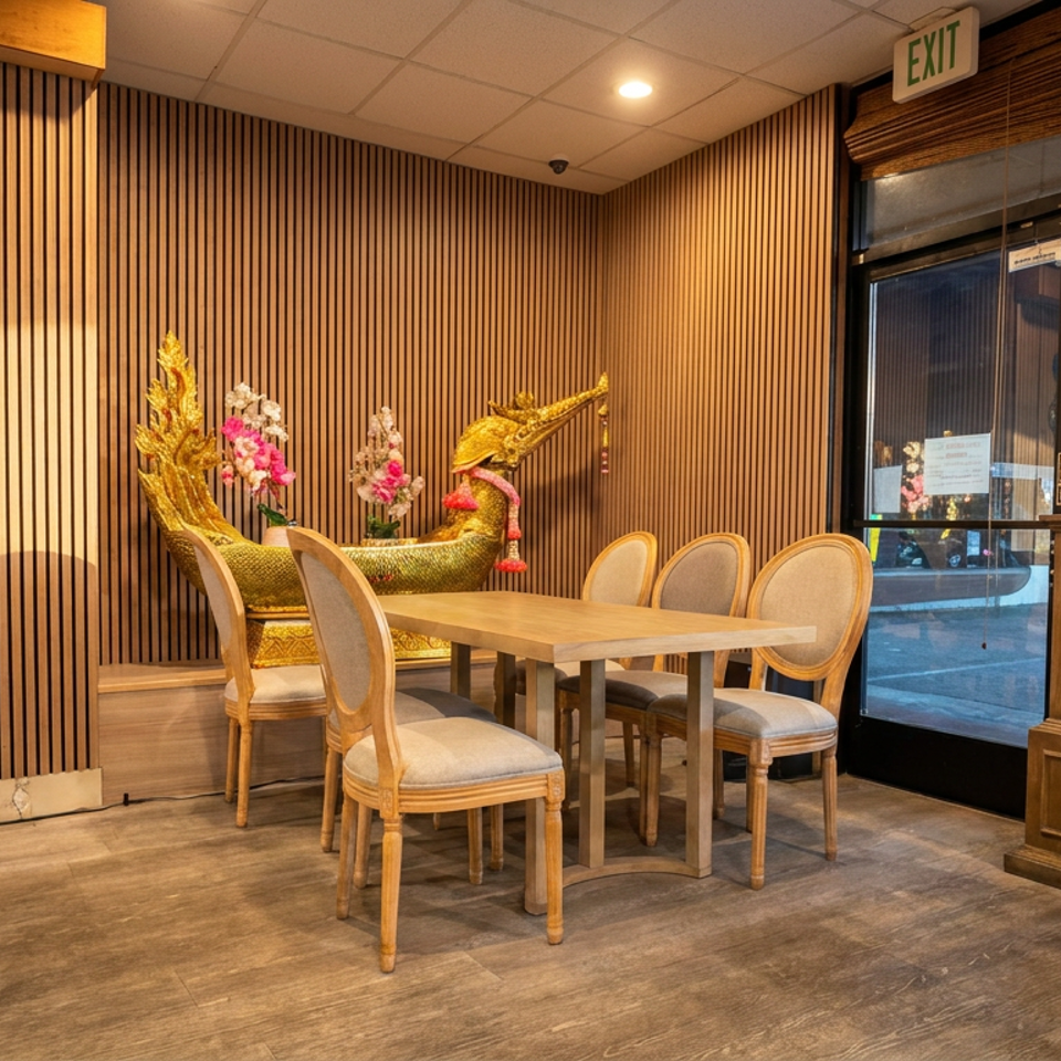 Elegant restaurant dining area with wooden slat walls, ornate golden dragon sculpture, floral arrangements, and upholstered chairs.
